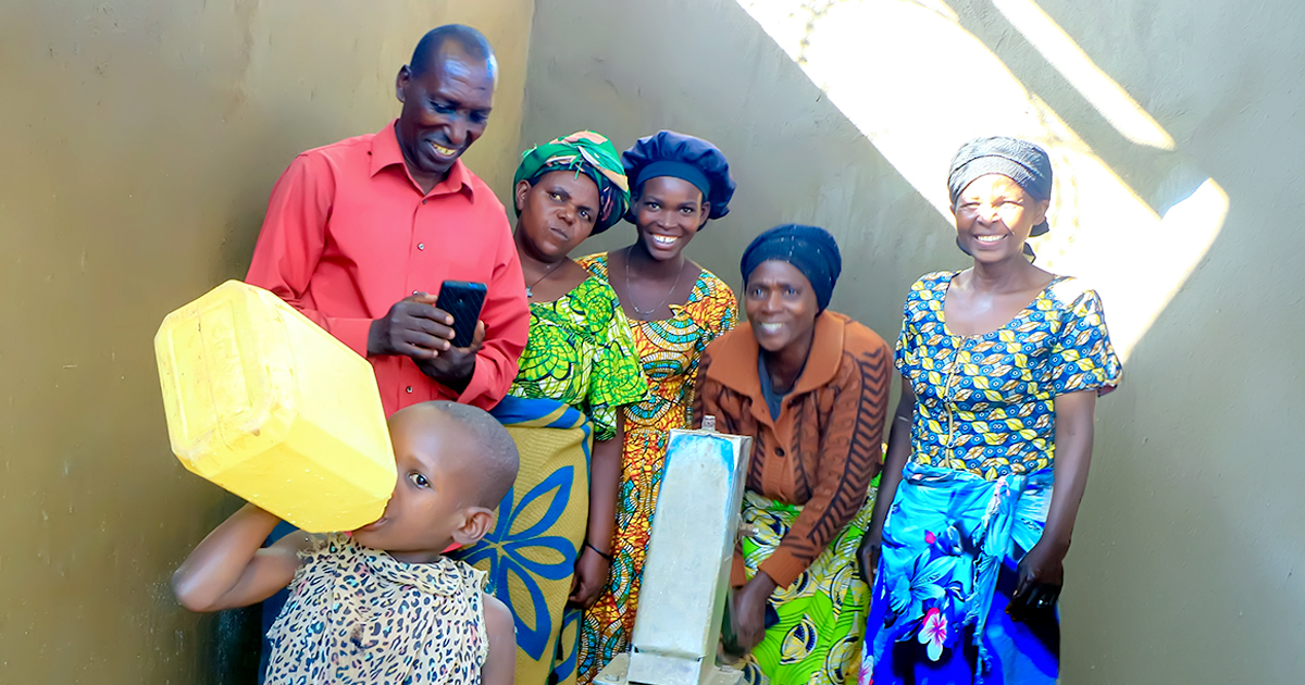 Six people standing together wearing colourful clothing